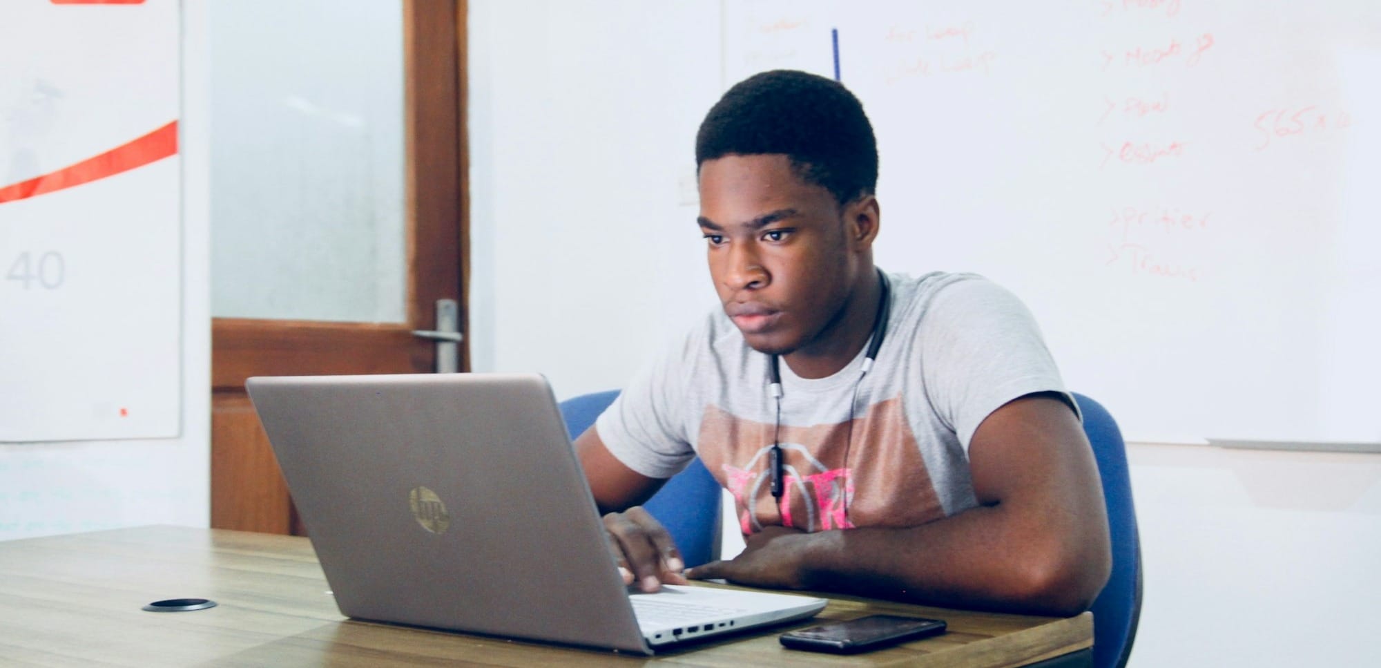 man in grey shirt using grey laptop computer